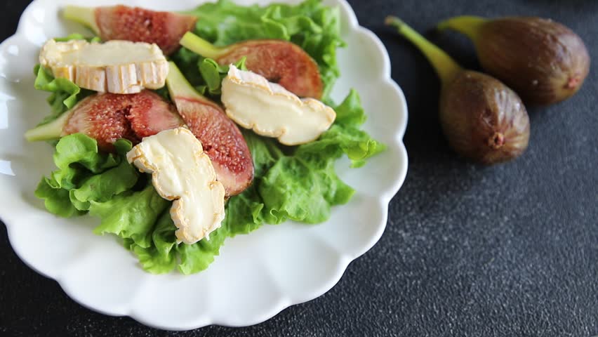 Figs salad, soft cheese, green leaf lettuce tasty snack fresh delicious gourmet food background on the table rustic food top view copy space keto and paleo diet vegetarian food