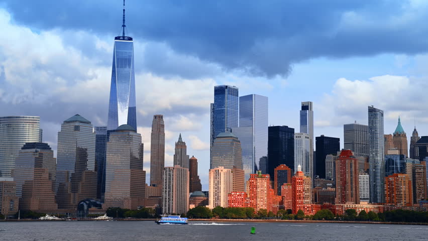 Dramatic cloudscape gathered in the sky over stunning Manhattan, New York, USA. Boats move by the riverscape.