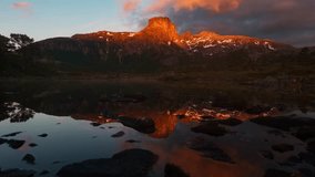 Stunning sunrise timelapse over snowy mountain peaks reflected in pristine alpine lake waters, creating dramatic golden light and perfect mirror reflections in serene wilderness. - Powered by Shutterstock - Get 15% off with code: PIKWIZARD15