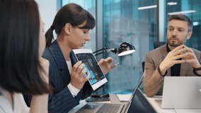 Confident businesswoman presenting data chart to diverse team during strategy meeting. Team members listening intently, analyzing graphs and financial growth at modern office workspace. - Powered by Shutterstock - Get 15% off with code: PIKWIZARD15