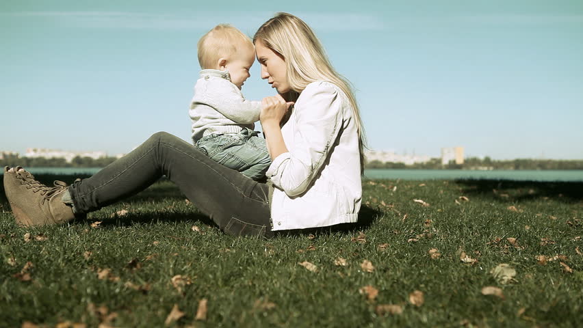 Baby funning with mother on the grass in park
