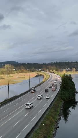 Aerial View of Cars and Trucks on a Curved Road Alongside Water in British Columbia, Canada