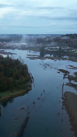 Misty River Inlet Landscape in British Columbia, Canada with Fog Over Distant Town