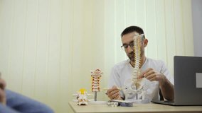 Chiropractor uses spine model to teach patient the importance of spinal health - Powered by Shutterstock - Get 15% off with code: PIKWIZARD15