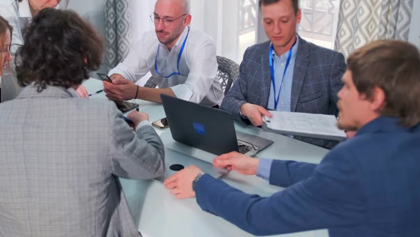 Corporate team of financial auditors, legal advisors, and tax inspectors collecting and analyzing data in a office. Laptops, tablets, and mobile devices for digital communication to conduct an audit.