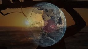 Male surfer on beach at sunset holding board as rotating globe overlay showing day-night tech demo. Ocean, sunset, silhouette, landscape, adventure, technology, specter - Powered by Shutterstock - Get 15% off with code: PIKWIZARD15