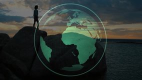 Sunset silhouetted woman standing on rocks initiating tech overlay showing world map while calling. Adventure, exploration, connectivity, innovation, outdoor, tranquility, digital - Powered by Shutterstock - Get 15% off with code: PIKWIZARD15