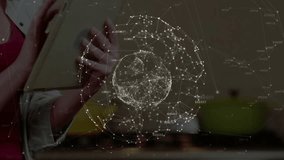Woman holding tablet in kitchen tapping screen rotating network globe and navigating interface. Technology, connectivity, innovation, digital, smart, interface, futuristic - Powered by Shutterstock - Get 15% off with code: PIKWIZARD15