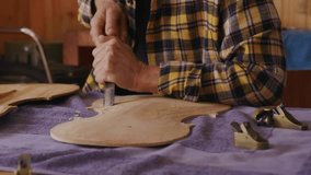 Senior woman carving wooden instrument top in woodshop, guiding chisel spawning live-stream emojis. Craftsman, woodworking, artisan, hand tools, craftsmanship, creative process, hobby - Powered by Shutterstock - Get 15% off with code: PIKWIZARD15