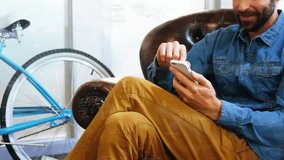 Seated man tapping smartphone screen activating floating data icons updating metrics for technology. Innovation, analytics, digital, futuristic, modern, productivity, professionalism - Powered by Shutterstock - Get 15% off with code: PIKWIZARD15