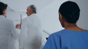 medical team walking down hospital corridor and updating animated numeric overlays for data review. Professional, collaboration, healthcare, diagnostics, technology, clinical, teamwork - Powered by Shutterstock - Get 15% off with code: PIKWIZARD15