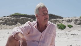 As social media reaction emojis rise senior man turning toward them laughing on beach. Beach, senior, leisure, celebration, communication, minimalist, vibrant - Powered by Shutterstock - Get 15% off with code: PIKWIZARD15