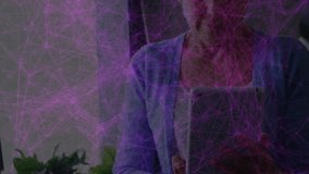 Senior woman lifting tablet by window activating purple graphic pulsing nodes monitoring network. Technology, connectivity, digital, elderly, relaxation, modern, home - Powered by Shutterstock - Get 15% off with code: PIKWIZARD15