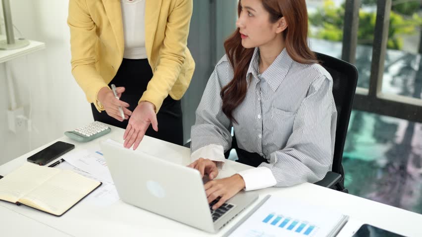 Adult Asian professional women working together on a business project in a modern office discussing strategy and data analysis for corporate growth - Powered by Shutterstock - Get 15% off with code: PIKWIZARD15