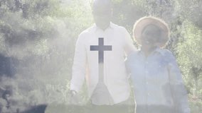 Senior man tilting phone capturing spiritual cloud overlay cross silhouette over couple in clearing. Serenity, spirituality, connection, contemplation, nature, mindfulness, silhouette - Powered by Shutterstock - Get 15% off with code: PIKWIZARD15