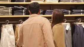 Happy Asian family couple shopping together at clothing store on holiday vacation. Man and woman enjoy urban lifestyle choosing and buy clothes at shopping mall. Consumerism and retail business. - Powered by Shutterstock - Get 15% off with code: PIKWIZARD15