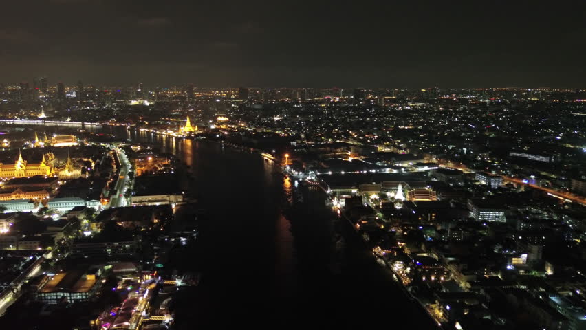 Aerial view of royal Grand palace and Wat Arun and Chao Phraya River at night in Bangkok, Thailand, 4k