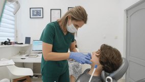 A female orthodontist performs a manual examination of a teenage patient's jaw and bite. A parent watches the consultation in the background as the doctor assesses the boy for future treatment. - Powered by Shutterstock - Get 15% off with code: PIKWIZARD15