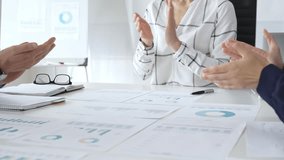 Business team clapping hands in meeting celebrating success with financial charts, data analysis, sales growth reports, and teamwork achievement in modern office - Powered by Shutterstock - Get 15% off with code: PIKWIZARD15