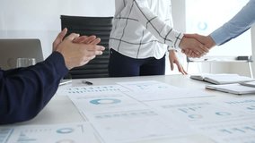 Business people shaking hands in office with financial charts, laptop and reports on desk top, symbolizing success, teamwork, agreement, collaboration and growth. Businesspeople handshake - Powered by Shutterstock - Get 15% off with code: PIKWIZARD15