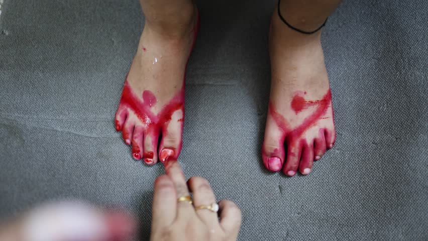 Hands Applying Red Pigment To girl Feet For Auspicious Event