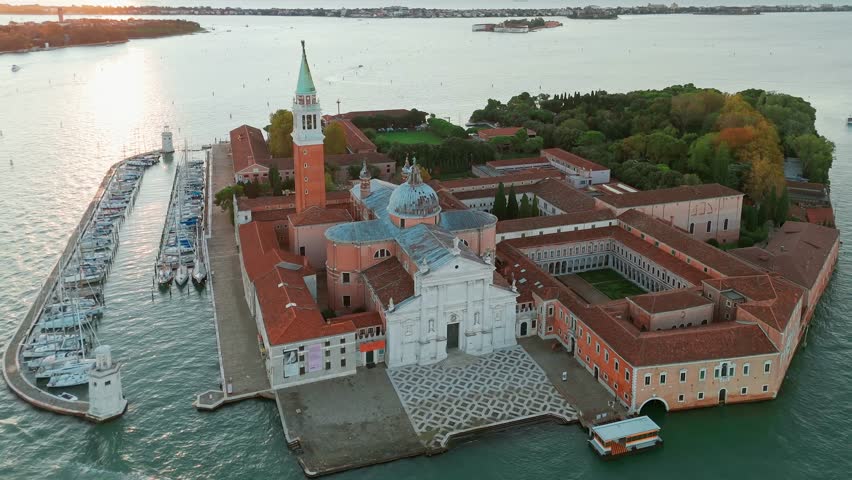Aerial view of San Giorgio Maggiore island and Grand Canal in Venice, Italy, at sunrise. Stunning landscape of the Venetian lagoon with historic architecture and calm morning atmosphere.