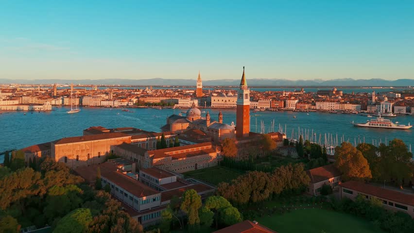 Aerial view of San Giorgio Maggiore island and Grand Canal in Venice, Italy, at sunrise. Stunning landscape of the Venetian lagoon with historic architecture and calm morning atmosphere.