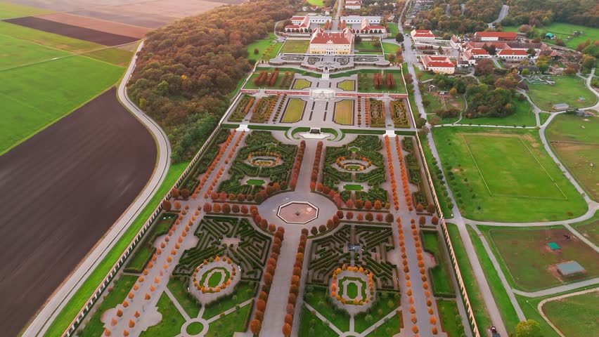 Aerial view of Schloss Hof Castle at sunset in Marchfeld, Austria. Majestic Baroque palace surrounded by beautifully landscaped formal gardens, a fine example of classical European architecture.