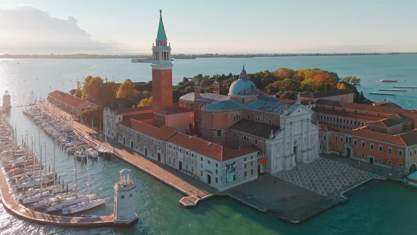 Aerial view of San Giorgio Maggiore island and Grand Canal in Venice, Italy, at sunrise. Stunning landscape of the Venetian lagoon with historic architecture and calm morning atmosphere.