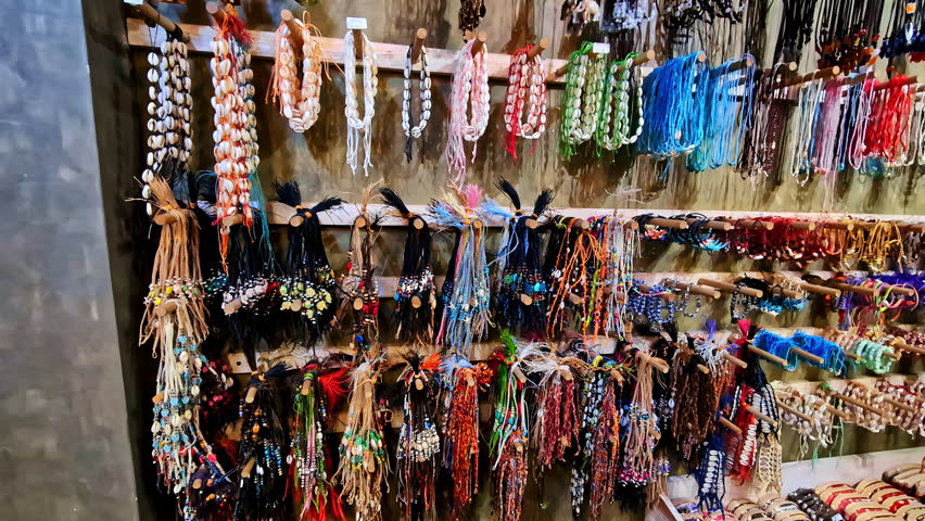 Toruist takes picture of artisan display of handmade shell necklaces and vibrant beaded jewelry in Ella Sri Lanka featuring rich colors creative crafts and cultural details
