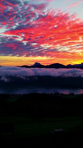 Vertical View Of Red Fiery Sky With Dense Clouds During Sunset. Panning Shot