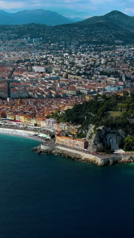 Magnificent 4K vertical aerial video of Nice showcasing turquoise Mediterranean, Promenade des Anglais, Alpine mountains and terracotta rooftops. Epic drone footage capturing French Riviera for mobile