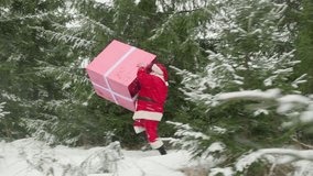 Santa Claus runs with huge gift box through winter forest with Christmas trees to congratulate people on New Year. - Powered by Shutterstock - Get 15% off with code: PIKWIZARD15