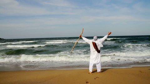 Middle Eastern Man with Staff Walking toward Sea Religious Concept HD