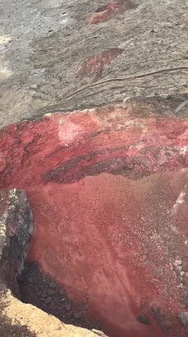 Vertical aerial helicopter view inside the red dormant crater of Fagradalsfjall volcano on the Reykjanes peninsula in Iceland during summer.