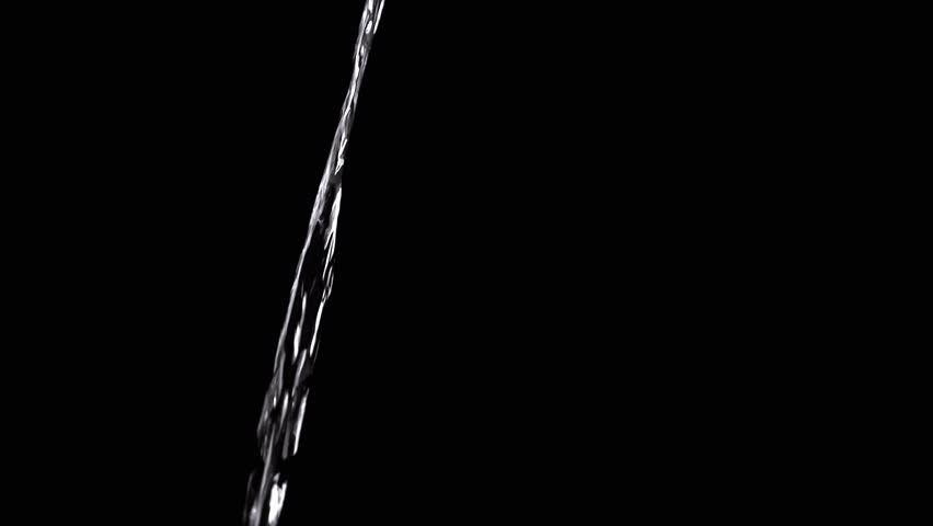 Thin Stream Of Water Pouring On Black Background. Close-up, slow motion. A clear stream of water flows down into empty space. Splashes. Abstract, texture, lighting. Clean water.