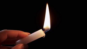Hand Holding Candle with Dripping Wax in Dark Room. Isolated One white burning wax candle in hand. Wax drops. Bright candle flame on black background. Concept of memory, celebration. - Powered by Shutterstock - Get 15% off with code: PIKWIZARD15