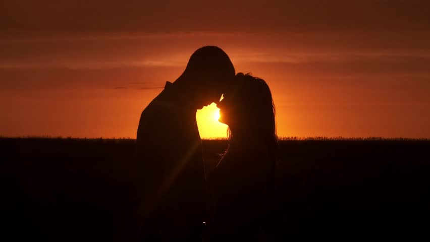 Silhouette of a couple in love in a romantic setting at sunset. Concept love story. Super slow-motion shot.