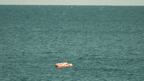 Woman, floating, sea, relaxing on an orange inflatable mattress under a clear sky - Powered by Shutterstock - Get 15% off with code: PIKWIZARD15