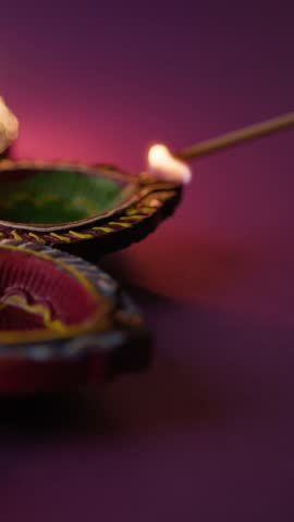 hand igniting festive Diwali diyas