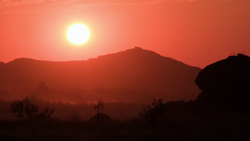 Timelapse of sun setting in mountain valley, evening gives way to night