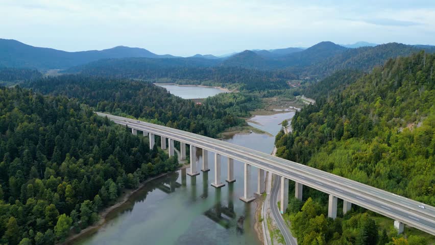 Panoramic aerial view of the toll highway (Autocesta A6) bridge near Fužine (Fuzine) and Lake Bajer in Gorski Kotar, Croatia, surrounded by green mountains and forests