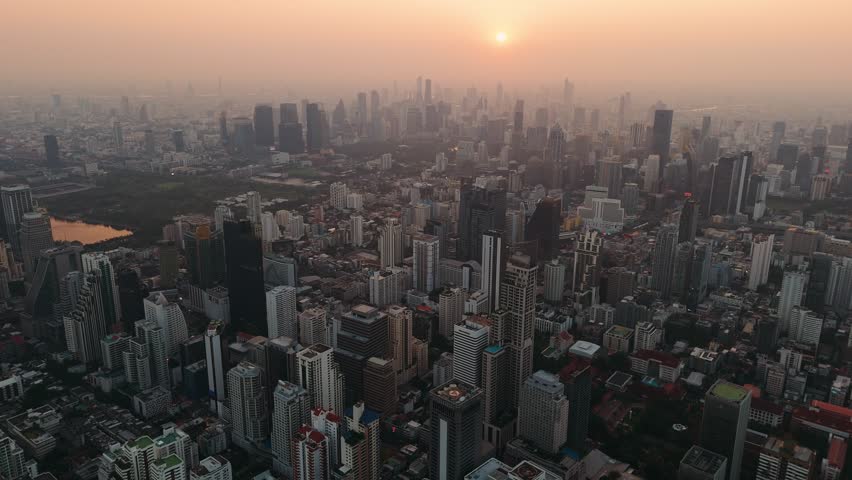 Bangkok skyline, Aerial View, towering skyscrapers silhouetted against vibrant sunset with sprawling urban landscape illuminating architectural grandeur, Thailand