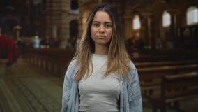Woman pointing index finger toward camera inside church building, wearing denim shirt and yellow nail polish; faith confidence. - Powered by Shutterstock - Get 15% off with code: PIKWIZARD15