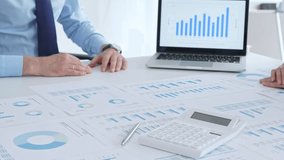 Business people shaking hands over financial documents and charts, confirming a successful agreement and partnership during a corporate meeting in the office - Powered by Shutterstock - Get 15% off with code: PIKWIZARD15