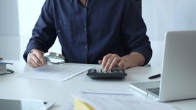 Businessman working in office using calculator and magnifying glass analyzing financial documents, performing accounting and financial analysis. Audit and taxes, business concept - Powered by Shutterstock - Get 15% off with code: PIKWIZARD15