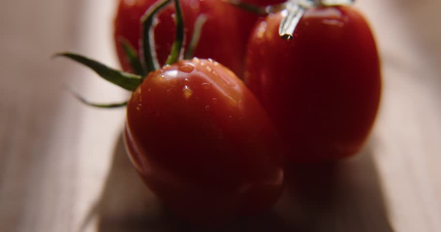 Closeup of fresh cherry tomatoes on cutting board. Water drops on vegetables.