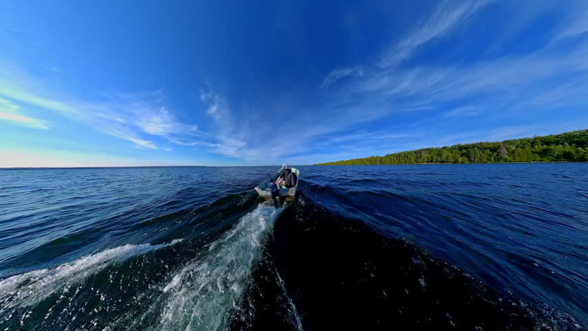 Man driving bass boat while woman seating at the front. Power sport, outboard fishing boat, with two people. Man and woman boating during fishing on the small v-hull boat.