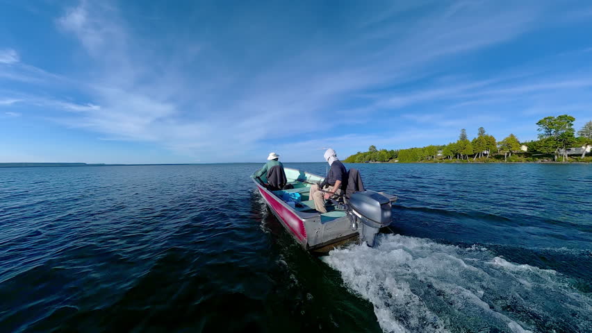 Man driving bass boat while woman seating at the front. Power sport, outboard fishing boat, with two people. Man and woman boating during fishing on the small v-hull boat.