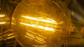 Extreme close up of glowing incandescent light bulb with intricate filament reflections. The bulb turns on and turns off, producing variations in brightness and reflections on transparent glass - Powered by Shutterstock - Get 15% off with code: PIKWIZARD15